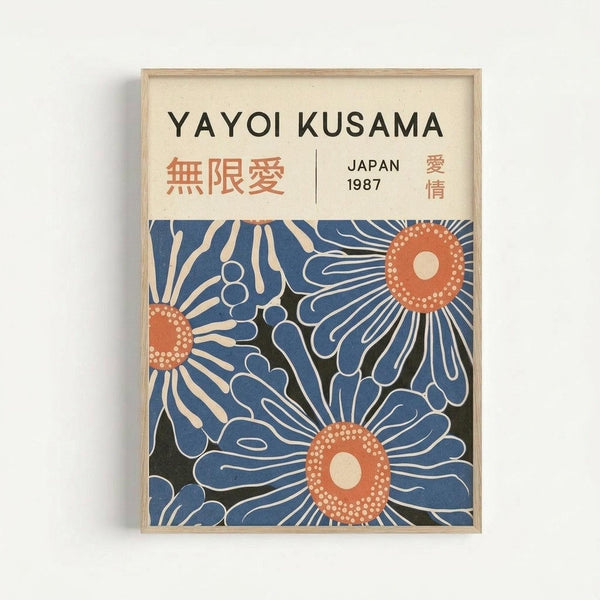 Framed art print featuring stylized blue flowers with orange centers and white dotted details on a cream background. The poster includes "YAYOI KUSAMA" at the top in black text, with Japanese characters and "JAPAN 1987" below. The artwork shows three large daisy-like blooms in navy and light blue tones with radiating petals, displayed in a light wood frame against a white wall.