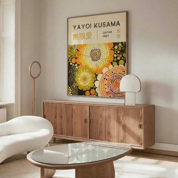 May include: Yayoi Kusama exhibition poster with colorful polka dot circles in yellow, orange, and green tones, displayed above a mid-century modern walnut credenza in a minimalist living room with white curved chair, glass oval coffee table, and soft natural lighting from window