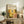 May include: Framed art print with yellow and orange circular dot patterns displayed on rustic wooden sideboard next to fern plant, books, and ceramic vases in neutral-toned living room setting