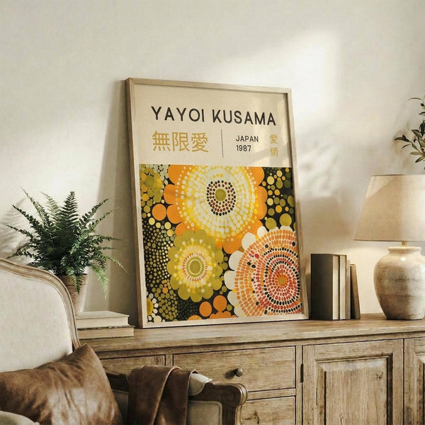 May include: Framed art print with yellow and orange circular dot patterns displayed on rustic wooden sideboard next to fern plant, books, and ceramic vases in neutral-toned living room setting