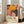 May include: A framed colorful botanical art print leaning against a white wall next to a beige upholstered sofa. The artwork features vibrant yellow flowers, pink blooms, and black polka dot patterns in a modern abstract style. Text at bottom reads "YAYOI KUSAMA" with Japanese characters and "MUSÉE D'ART MODERNE DE LA VILLE DE PARIS". Natural sunlight streams through nearby windows onto light wooden floors.
