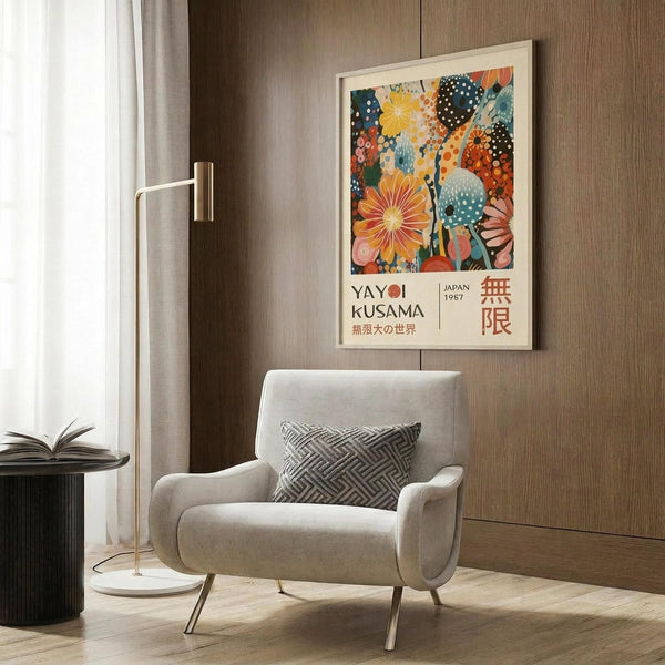 May include: Colorful abstract art poster with vibrant floral and polka dot patterns in orange, blue, and pink tones, featuring Japanese text, displayed in light wooden frame on wood-paneled wall above modern cream armchair with geometric pillow and brass floor lamp in contemporary living room setting.