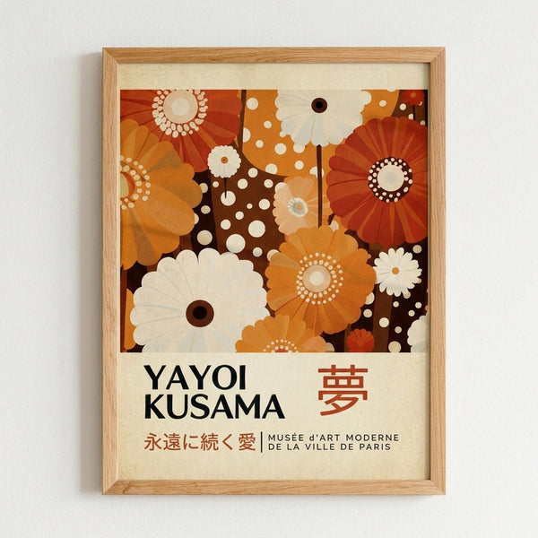 Framed art print featuring abstract floral design in warm orange, cream, and brown tones with polka dot patterns. Shows stylized flowers and circular motifs in retro color palette. Text reads "YAYOI KUSAMA" with Japanese characters and "MUSÉE D'ART MODERNE DE LA VILLE DE PARIS" below. Natural wood frame displayed against white wall background.