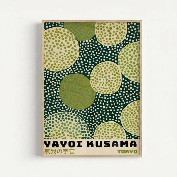 A framed art print featuring abstract polka dot patterns in shades of green, cream, and dark teal. Large overlapping circles filled with dots create a playful, organic composition against a dotted background. The poster includes "YAYOI KUSAMA" in bold black letters, Japanese characters, and "TOKYO" in green text at the bottom. The artwork is displayed in a light wood frame against a white wall.