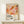 May include: Framed abstract art poster with organic pink, orange, coral and burgundy shapes and dotted patterns, displayed on light wood surface with small wrapped gift box. Wood frame against white wall in minimalist setting.