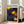 May include: A framed poster with Yayoi Kusama's signature polka dot style featuring three large yellow spiral orbs against a deep blue background filled with golden dots of varying sizes. The artwork is displayed in a light wooden frame leaning against a white wall next to a beige armchair with gray throw pillows. Natural sunlight streams through tall windows, creating a bright, modern living room setting on light wooden floors.