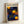 Framed poster featuring Yayoi Kusama-inspired artwork with bright yellow and orange circular forms scattered across a deep blue background. The composition includes dotted patterns in various sizes creating a cosmic, polka-dot design. Text at top reads "YAYOI KUSAMA" in black letters with Japanese characters below and "KYOTO" in orange. The poster is displayed in a light wooden frame leaning against a white wall.