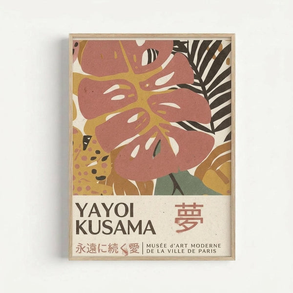 Framed art print featuring abstract tropical foliage in muted coral, mustard yellow, sage green and black tones. The botanical illustration shows large monstera leaves and palm fronds in a modern, stylized design. Text at bottom reads "YAYOI KUSAMA" with Japanese characters and "MUSÉE d'ART MODERNE DE LA VILLE DE PARIS" in smaller print. The print is displayed in a light wooden frame against a white wall.
