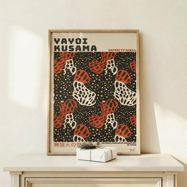May include: Framed poster with black background featuring red and white polka-dotted mushroom pattern, displayed on light wood console table next to small wrapped gift with twine and greenery sprig against cream colored wall
