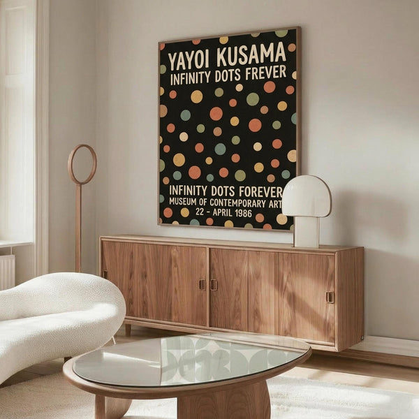 May include: Modern living room with walnut credenza displaying framed poster featuring colorful polka dots on black background with white text. Room styled with white curved chair, glass-top oval coffee table, and floor lamp. Poster shows various sized circles in muted orange, yellow, green, and coral tones against dark backdrop.