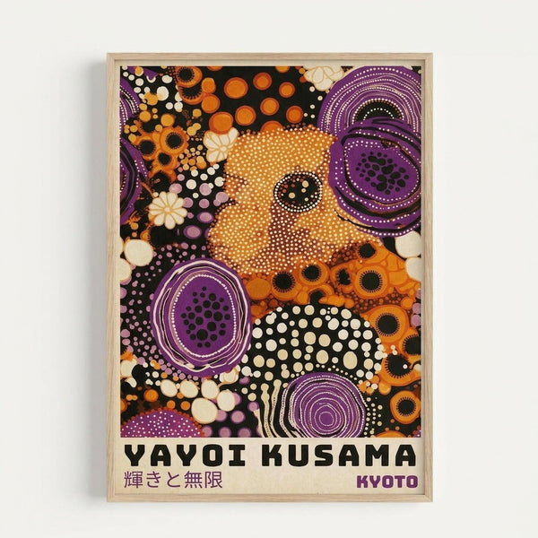 Framed art print featuring abstract composition in vibrant orange, purple, black and white. Large dotted circles, concentric rings, and organic shapes create a psychedelic pattern. Japanese text appears at bottom with "YAYOI KUSAMA" and "KYOTO" in bold black letters. Light wood frame against white wall background.