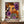 May include: Framed poster with colorful abstract dot artwork featuring orange, purple, black and white circular patterns, displayed on wooden sideboard next to white ceramic vase and stacked books against cream wall with white molding.