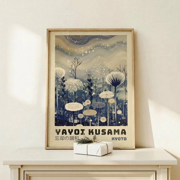May include: Framed art print displayed on light wood shelf against cream wall, featuring stylized mushrooms and flora in blue and cream tones with swirling sky dotted with white spots, Japanese text at bottom, small wrapped white gift box with greenery beside frame