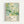 Framed art print featuring abstract underwater scene with floating green, teal and white circles of various sizes scattered across pale green background. Delicate grass-like elements emerge from bottom corners. Bottom section displays black text "YAYOI KUSAMA" with Japanese characters, "JAPAN 1987" and green Japanese text on cream background. Natural wood frame against white wall.