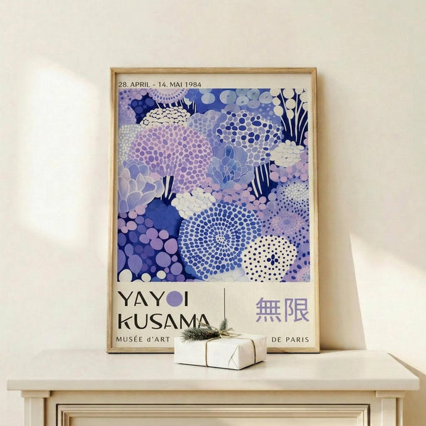 a framed poster of a colorful abstract floral design, hanging on a wall above a small white table.
