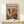 a framed poster with a vibrant abstract painting on the cover, displayed on a white shelf or table.