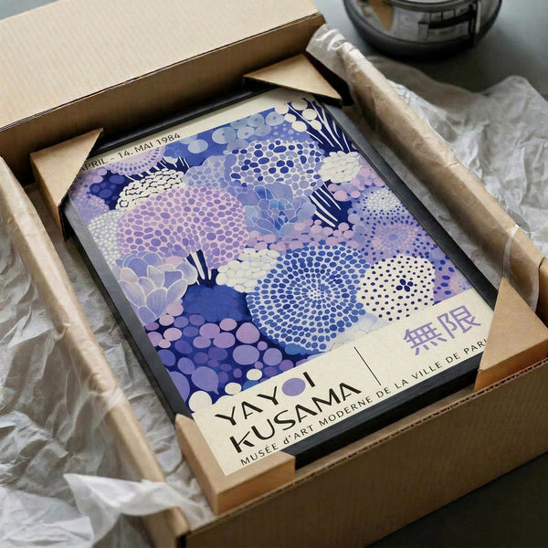 A framed poster of a colorful abstract floral design is displayed in a cardboard box.