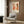 a modern living room with a white armchair, a floor lamp, and a framed poster on the wall.