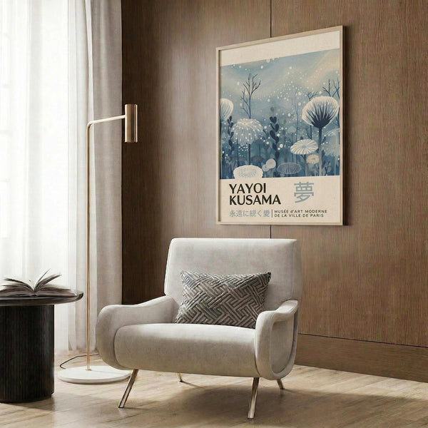 a modern living room with a white armchair, a floor lamp, and a framed poster of a floral design on the wall.