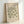 The image is a framed poster featuring a repeating pattern of green leaf-like shapes, with the text "MATISSE PAPiers D'ECOUPS" and "BERGGRUEN & CIE" printed on it.