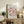 a framed poster of a floral design with the text "MATISSE PAPiers découpés" and "BERGRUEN & CIE" printed on it, placed on a wooden cabinet or shelf in a living room setting.