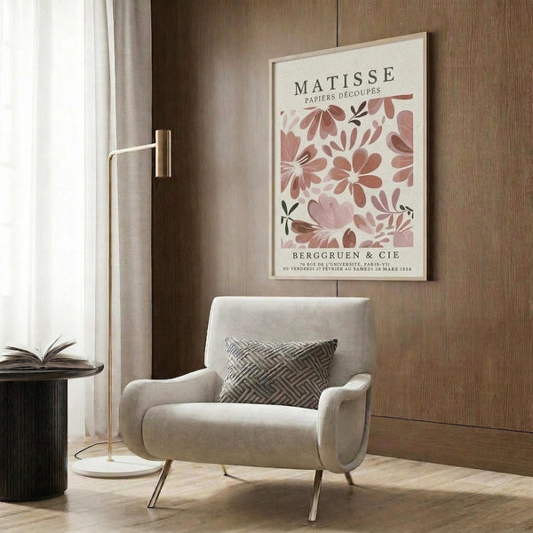 a living room with a white armchair, a floor lamp, and a framed poster of the famous painting "Matsisse" by the artist Henri Matisse.