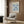 a living room with a white armchair, a floor lamp, and a framed poster of the Métisse painting "Papiers D'ocuples" hanging on the wall.
