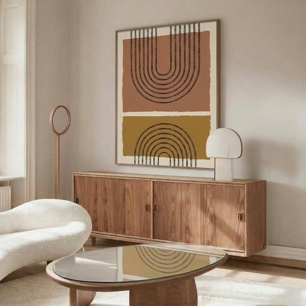 May include: Modern living room interior with walnut credenza displaying the geometric arch poster in warm terracotta and mustard colors. White curved chair, glass coffee table with wooden base, brass floor lamp, and dome table lamp create a mid-century modern aesthetic. The framed artwork features concentric semicircular arches in earth tones against cream background, complementing the neutral wall and natural lighting from nearby window.