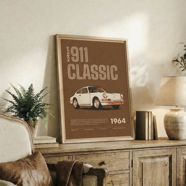 May include: Framed brown poster featuring white vintage Porsche 911 with "PORSCHE 911 CLASSIC 1964" text, displayed on rustic wooden console with books, ceramic vase, and fern plant in cozy living room setting with beige armchair and neutral walls