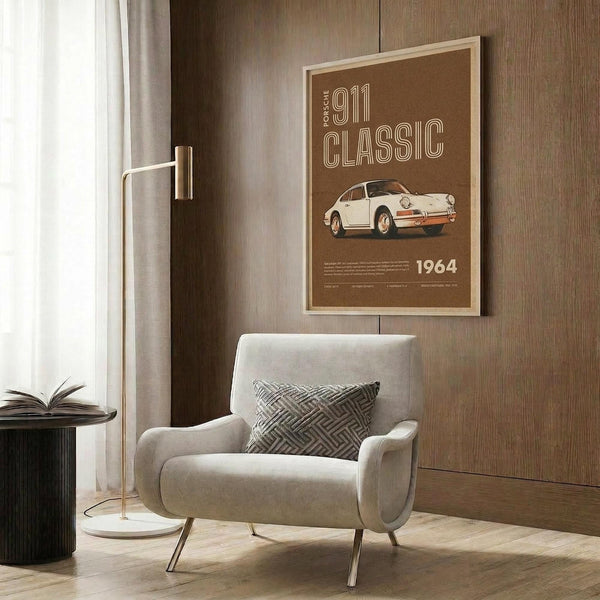 May include: Framed brown poster showing white vintage sports car with "911 CLASSIC" and "1964" text, displayed on wood paneled wall above beige upholstered armchair with geometric patterned pillow, brass floor lamp, and dark round side table with open book in modern living room setting