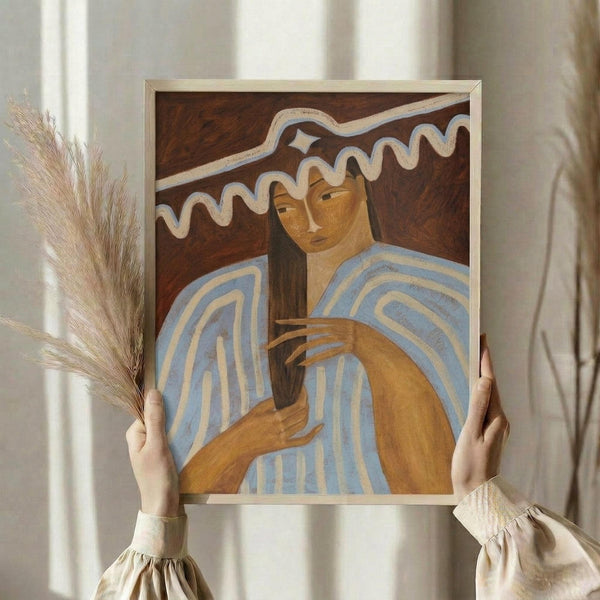 May include: Hands holding framed artwork featuring a woman with long dark hair in blue and cream striped clothing, painted in warm earth tones against a dark wooden background with decorative white curved lines above. Person wears cream ruffled sleeves and holds dried wheat stems. Soft natural lighting creates gentle shadows on neutral curtained background.