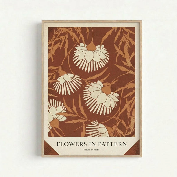 May include: Framed botanical art print mounted on white wall. Light wood frame contains artwork with rust brown background featuring cream-colored stylized flowers with radiating petal patterns and golden foliage. White mat border surrounds the design. Title text reads "FLOWERS IN PATTERN" with French translation below. Warm earth tone color palette with vintage botanical illustration style.