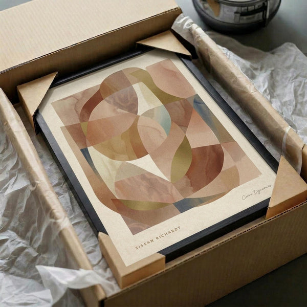 May include: Abstract geometric art print with overlapping curved shapes in warm earth tones including terracotta, sage green, cream and muted pink, displayed in a black frame inside an open cardboard shipping box with protective tissue paper and wooden dowels for packaging.