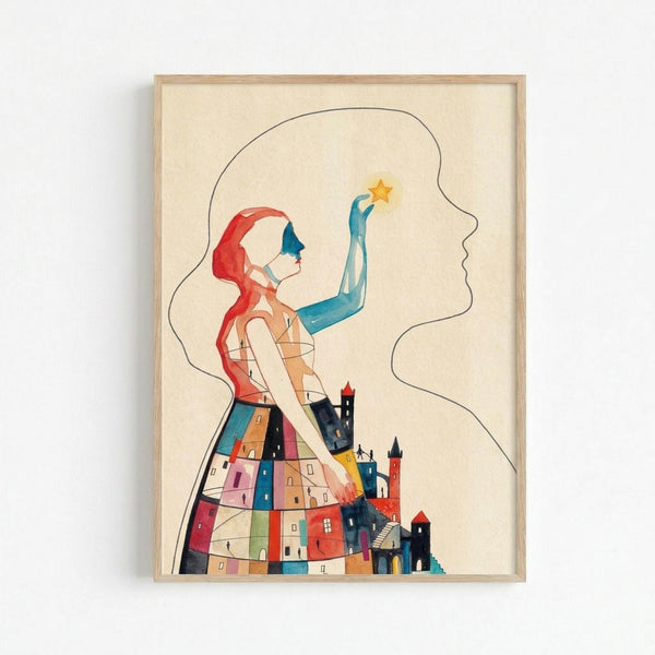 Framed watercolor illustration showing a woman with flowing red hair and blue mask reaching toward a golden star. Her dress transforms into a colorful village of small houses and buildings in various hues. The artwork is set against a cream background in a light wood frame mounted on a white wall.