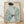 May include: Framed art print displaying a woman in profile view wearing a light blue kimono with white wavy stripes and floral patterns featuring green leaves and small blue flowers. She has black hair styled in a traditional updo with a blue ornament. The artwork has a cream background and is shown in a thin wooden frame, leaning against a white textured wall on light wood flooring with natural shadows.