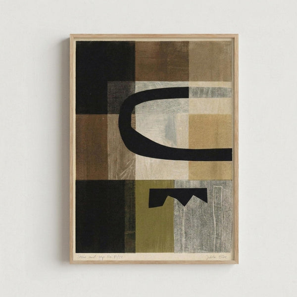 Framed abstract artwork featuring geometric shapes and curved black lines in a collage-style composition. The piece uses a muted color palette of browns, beiges, blacks, and olive greens with varied textures and overlapping rectangular forms. A prominent curved black line flows through the center, with angular geometric elements below. The artwork is displayed in a light wood frame against a white wall, showing subtle texture variations and layered translucent effects throughout the design.