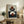 May include: Abstract geometric art print in light wood frame displayed on rustic wooden sideboard. Artwork features terracotta circles and navy semicircles arranged in balanced composition on light background. Room styled with leather armchair, potted fern, ceramic vases, and stacked books creating warm, modern home decor setting.