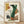 May include: Framed abstract art print featuring colorful geometric shapes and forms in green, orange, yellow, and brown tones with "MODERN STEPS" text, displayed in light wood frame against white textured wall on wooden floor with natural lighting creating soft shadows