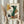 May include: Person holding framed abstract art print featuring geometric shapes in green, orange, yellow, and cream tones with "Modern Steps" text, displayed alongside dried pampas grass against neutral curtained background in light wood frame
