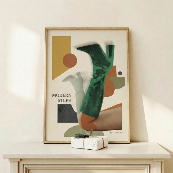 May include: Framed abstract art print in light wood frame leaning against white wall on wooden shelf. Artwork features geometric shapes in mustard yellow, burnt orange, sage green, and black with person wearing emerald green ribbed sweater and brown pants. Text reads "Modern Steps" and "Style No 24". Small wrapped white gift box with greenery sits on shelf in front of frame.