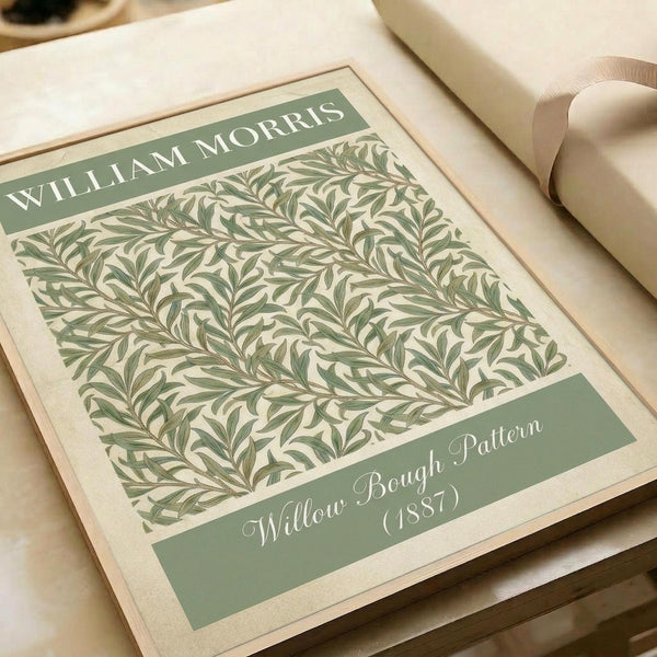 May include: Vintage botanical art print featuring intricate green willow branch pattern on cream background, displayed in an open art book or portfolio with beige ribbon visible. The design shows flowing, intertwining leaves and branches in muted sage green tones with decorative text banners at top and bottom against soft natural lighting.