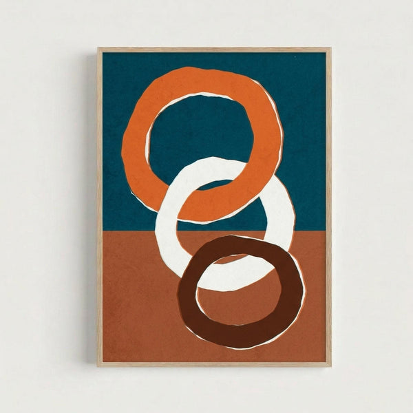 Abstract artwork featuring three interlocking rings in orange, white, and dark brown against a two-toned background of deep teal blue on top and terracotta orange on bottom. The rings have organic, hand-drawn edges with visible brushstroke textures. Displayed in a light wood frame against a white wall, creating a modern minimalist aesthetic with warm earth tones and bold geometric shapes.