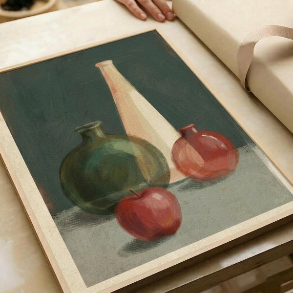 May include: Still life painting displayed in an open art book or portfolio, showing green ceramic vase, tall cream-colored bottle, red ornamental vase, and red apple arranged on neutral surface against dark teal background. Warm lighting highlights the objects' rounded forms and glossy textures in this classic composition style.