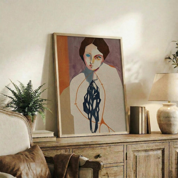 May include: Framed modernist portrait artwork displayed on rustic wooden sideboard in neutral-toned living room. The stylized painting features a figure with dark hair in white clothing against purple and orange geometric background. Warm lighting illuminates the wood furniture, decorative pottery, books, and fern plant creating a cozy interior scene.