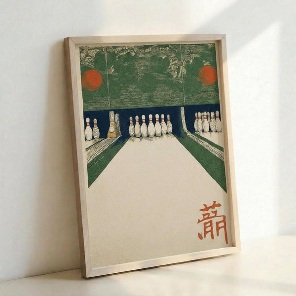 A framed vintage Japanese woodblock print depicting a bowling alley interior with green textured walls, white bowling pins arranged at the end of pale wooden lanes, and two orange circular lights. The perspective shows the view down the lanes toward the pins, with Japanese characters in red ink in the bottom right corner. The artwork is displayed in a light wooden frame against a white wall.