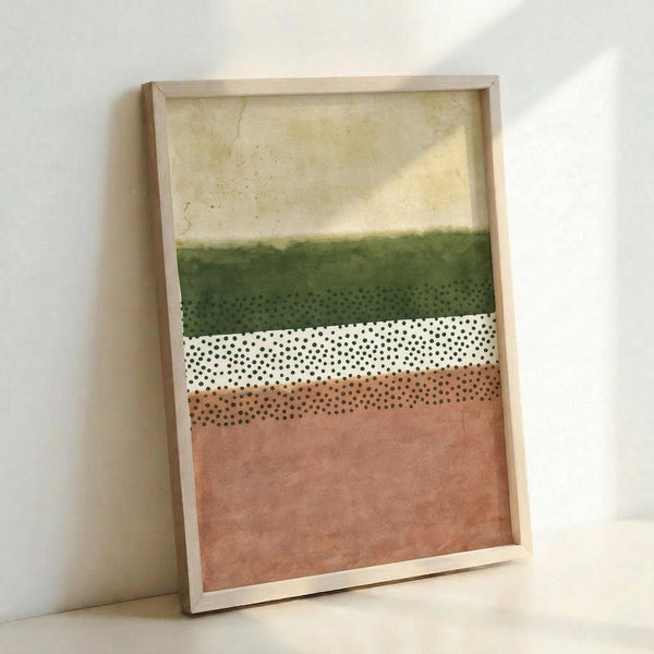 May include: Framed abstract art print leaning against white wall, featuring horizontal bands of watercolor-style colors including cream, olive green, white with black polka dots, peach, and terracotta pink. Natural wood frame with visible texture and weathered appearance on the artwork surface.