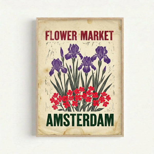 Vintage-style poster with aged cream background featuring purple iris flowers and red blooms. Bold red text reads "FLOWER MARKET" at top, green "AMSTERDAM" at bottom. Artwork displayed in light wood frame against white wall with subtle shadow, showing weathered texture and distressed edges typical of retro travel prints.