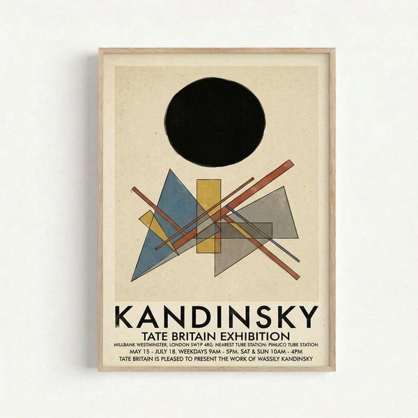 Framed exhibition poster featuring Kandinsky's abstract geometric artwork with a black circle at top, intersecting triangles and rectangles in blue, yellow, and gray tones below, and black text reading "KANDINSKY TATE BRITAIN EXHIBITION" with venue and date details. Light wood frame against white wall background.