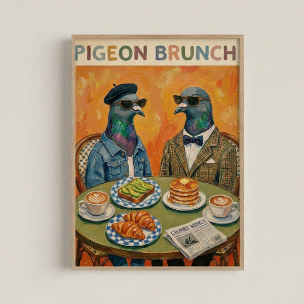 Framed poster artwork showing two anthropomorphic pigeons wearing sunglasses and human clothing sitting at a green round table for brunch. The pigeon on the left wears a black beret and denim jacket, while the right pigeon sports a bow tie and brown checkered suit jacket. Between them are plates with avocado toast, croissant, and pancakes, plus two coffee cups with latte art and a newspaper titled "Crumbs Weekly." The background features warm orange and yellow brushstrokes in an expressive paint