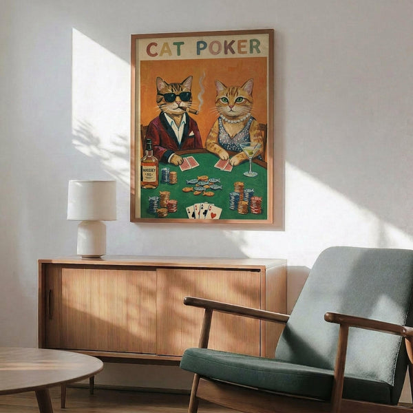 May include: Vintage-style poster showing two anthropomorphic cats playing poker at green felt table with chips, cards, and whiskey bottle. Male cat wears sunglasses and burgundy jacket, female cat in sparkly dress holds martini. Warm orange background with colorful "CAT POKER" text. Displayed in wood frame above mid-century modern credenza with white lamp and teal upholstered chair in sunlit room.